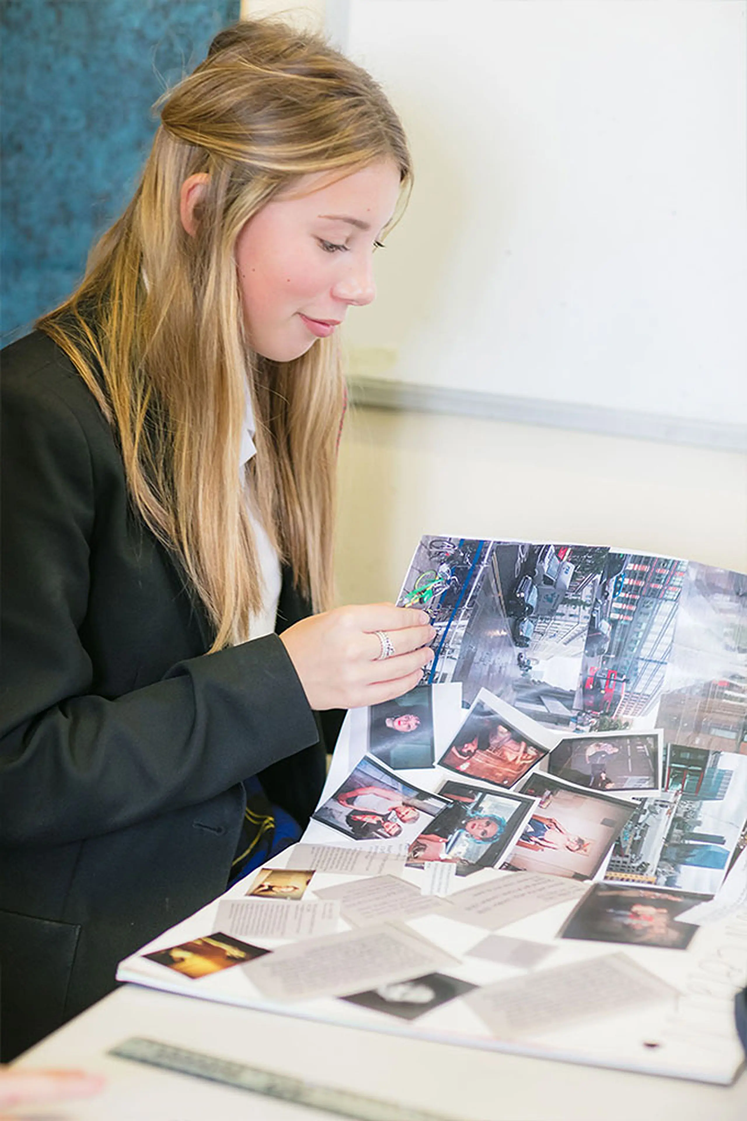 Female student looking through a photo album while working at a desk
